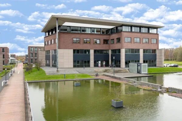 Modern kantoorgebouw aan de Boris Pasternaklaan met omliggende waterpartijen en een brug.